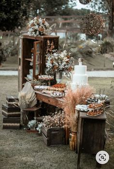 a wedding cake sitting on top of a wooden table next to other items and flowers