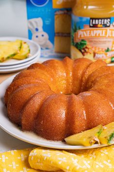 a bundt cake sitting on top of a white plate next to pineapple slices