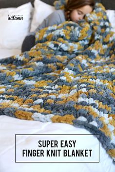 a woman laying in bed under a crocheted blanket with the text super easy finger knit blanket