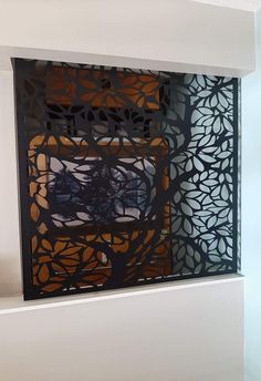 an intricate metal screen in the corner of a room with white walls and flooring