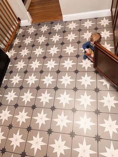 a little boy sitting on the floor in front of a door looking down at something