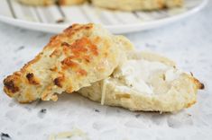 two plates with scones on them and one is half eaten, the other half has cream cheese