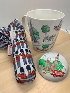 an umbrella, cup and saucer sitting on a wooden table next to a button