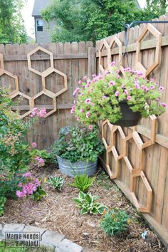 a wooden fence with flowers in it and some plants growing out of the top one