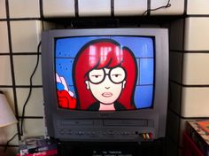 an old television with a cartoon character on it's screen in front of a wall