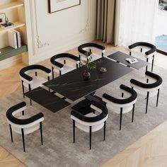 a black and white dining table with six chairs in the middle is surrounded by an area rug