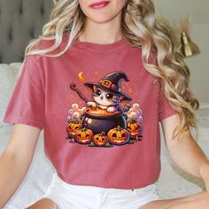 Get into the spooky spirit with this adorable and  Halloween cat making a witches brew! This shirt is perfect for Halloween lovers of all ages. Whether you're attending a costume party, handing out candy, or just feeling festive, this charming design is sure to make you the center of attention. Embrace the magic of the season with this whimsical and cozy shirt--purrfect for Halloween night! Comfort Colors introduces the "Comfort Colors 1717" garment-dyed t-shirt The soft-washed, garment-dyed fabric brings extra coziness to your wardrobe while the relaxed fit makes it an excellent daily choice. The double-needle stitching throughout the tee makes it highly durable while the lack of side-seams helps the shirt retain its tubular shape. Spooky Halloween T-shirt With Cat Design, Spooky Cat Design T-shirt For Fall, Spooky Halloween Cat Design Top, Halloween Lovers, Witches Brew, Cat Shirt, Halloween Night, Halloween Women, Cat Shirts