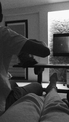 black and white photograph of two people watching television