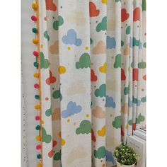 a curtain with colorful clouds on it next to a window