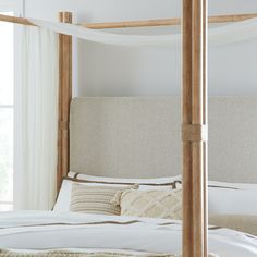 a bed with white sheets and pillows in a bedroom