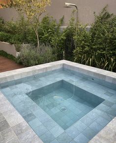 an empty swimming pool in the middle of a garden