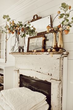 an old fireplace with apples on it and a mirror over the mantle in front of it