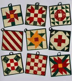 nine quilted coasters with red and green designs on them are arranged in rows