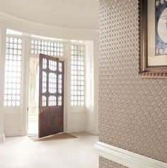 an empty room with a door and wallpaper on the walls is pictured in this image