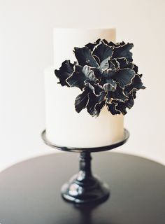 a white and black cake with flowers on top