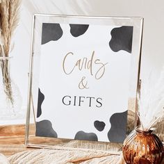 a sign that says candles and gifts next to a vase with some dry grass in it