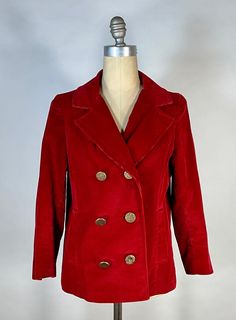 Get a classic look, popularized by Mary Tyler Moore in the early 70's, with this stand-out red peacoat... This incredibly lush jacket or 'Pea Coat' comes in a warm, medium weight cotton corduroy with semi-wide wales. The reason I think it may be as old as late 1960's, is due to the bracelet-length sleeves (not full length) and slightly cropped cut -however, these jackets were really more popular by the early to mid 1970's (thanks to Mary Tyler Moore, as stated above). This version has a mock double-breasted front closure, adorned with funky antiqued gold buttons (one of these has been replaced with a look-alike). The collar has notched lapels, and there are two small welt pockets at waist area. Lined with a lightweight red acetate fabric. No labels or maker's marks to note any where. Overa Red Winter Outerwear With Double Button Closure, Red Collared Outerwear With Button Closure, Red Double-breasted Pea Coat With Buttons, Vintage Red Blazer With Buttons, Red Corduroy Jacket, Vintage Red Outerwear With Buttons, Red Peacoat, Tyler Moore, Mary Tyler Moore