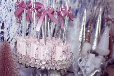 there is a cake with pink icing and bows on it, surrounded by other decorations