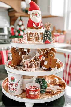 a three tiered tray with gingerbreads, cookies and santa clause on it