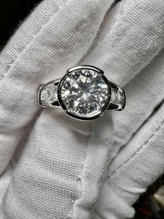 a diamond ring sitting on top of a white cloth