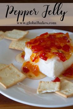 a white plate topped with crackers and cheese covered in ketchup on top of it