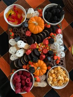 a table topped with halloween treats and desserts