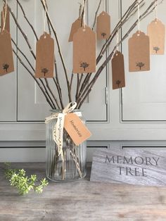 a vase with some branches and tags hanging from it