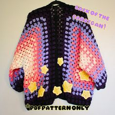 a crocheted jacket with stars on it hanging from a hook off the wall