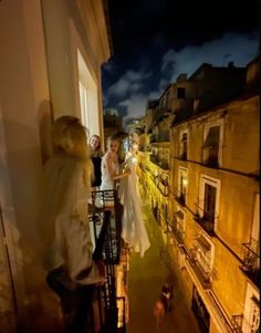 the bride and groom are walking down the street at night