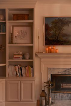 a living room filled with furniture and a fire place next to a painting on the wall