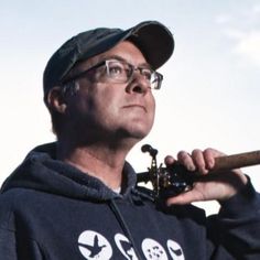 a man holding a baseball bat while wearing a hoodie