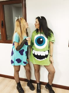 two women dressed up as monsters standing next to each other in front of a mirror