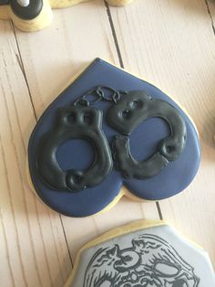 two decorated cookies sitting on top of a wooden table