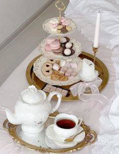 a tray with tea and cookies on it next to a white tablecloth covered table