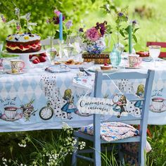 a table set up for a tea party in the grass