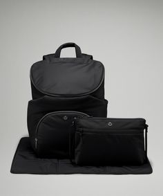 two pieces of black luggage sitting on top of each other in front of a gray background