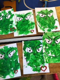 some green paper with faces on them and hearts in the middle, sitting on a table