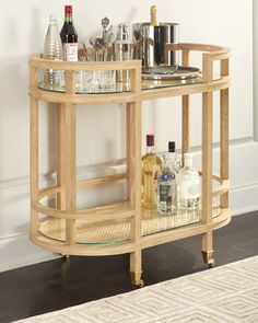 a wooden bar cart with bottles and glasses on it