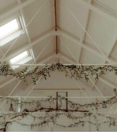 an indoor wedding venue with greenery hanging from the ceiling