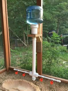 a water dispenser on the side of a window sill in an enclosure