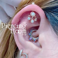 a close up of a person's ear with three different piercings on it