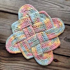 two crocheted mitts sitting on top of a wooden table