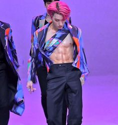 two men with pink hair and no shirt on walking down the runway at a fashion show