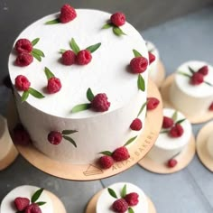 a white cake with raspberries on it