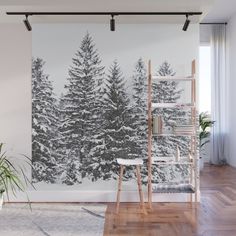 a living room with a large wall mural featuring trees