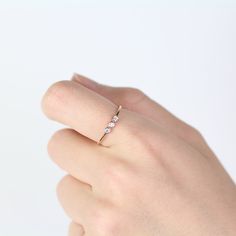 a woman's hand with a diamond ring on her left wrist, against a white background