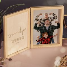 an open wooden photo frame with a father and son on it