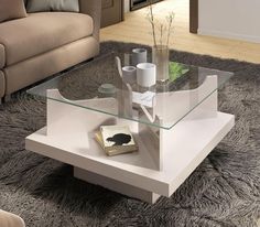 a glass table with a book on it in the middle of a living room area