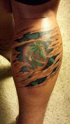 a person with a tattoo on their leg that has a palm tree in the center