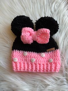 a crocheted minnie mouse hat with a pink bow on the front and black ears